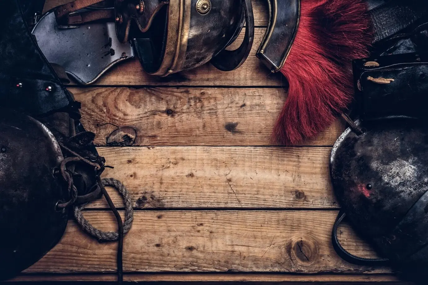 Vollständige Kampfausrüstung eines antiken griechischen Kriegers vor einem Hintergrund aus Holzbrettern.